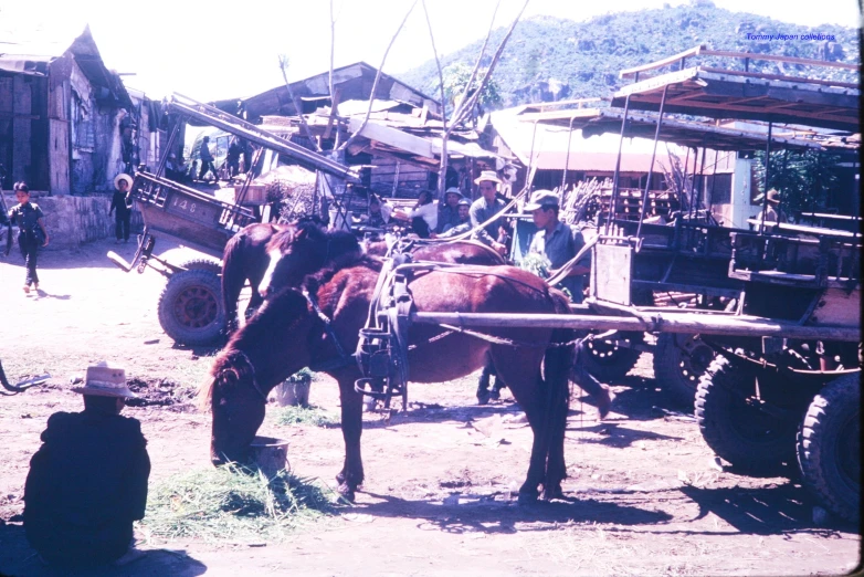 people walking in front of an old fashioned farm