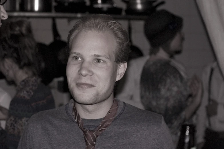 a man standing in front of other people at a dinner