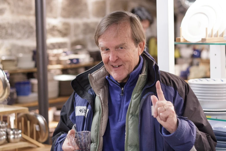 a man standing in front of a counter with a glass