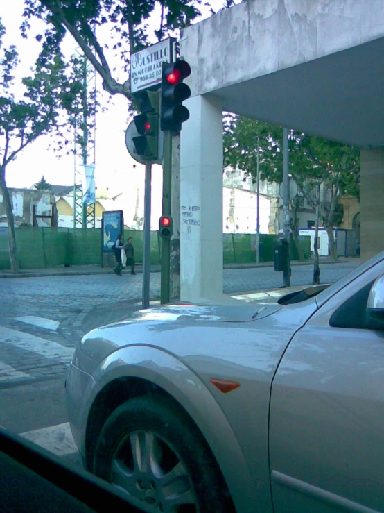 car stopped at stop light at intersection under overpass