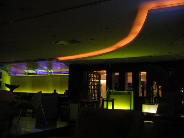 an illuminated bar and lounge in a large building