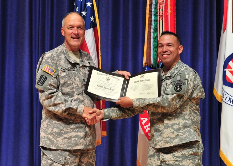 two men in military uniforms holding a certificate