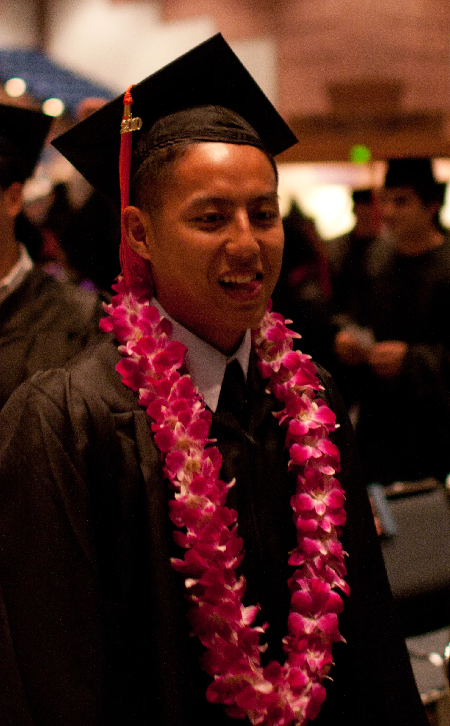 a man in a mortar with flowers on his graduation gown