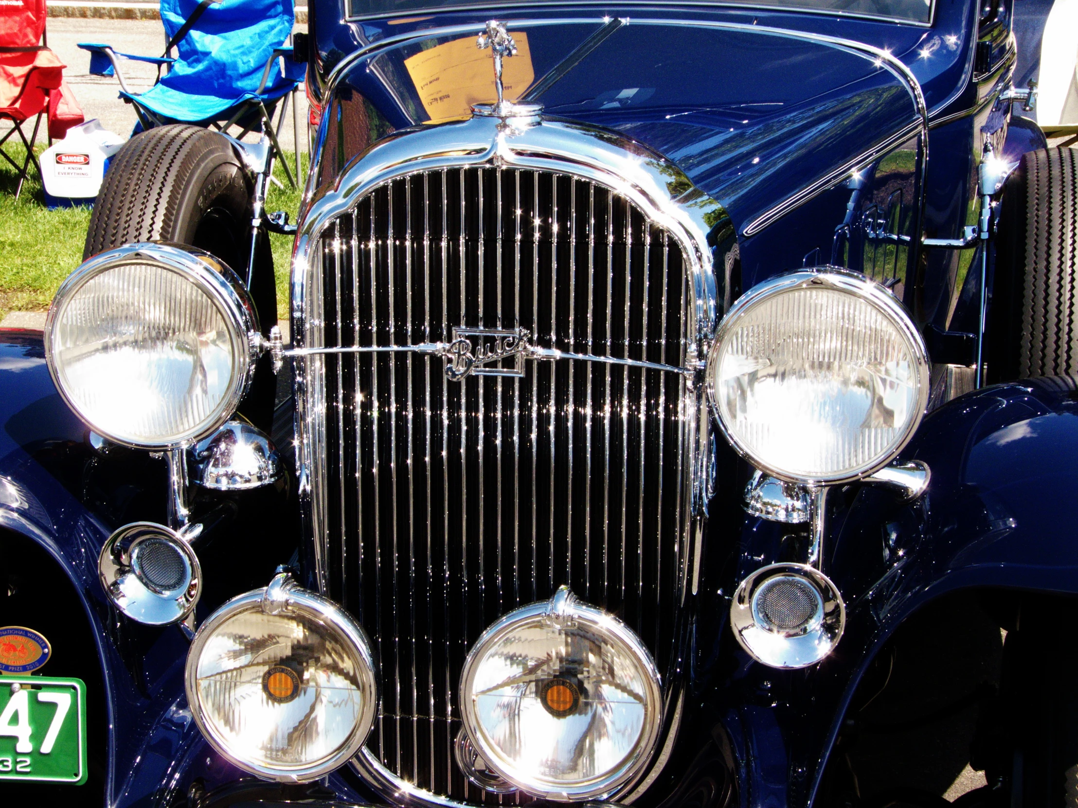 an old fashioned, blue car sits in the street