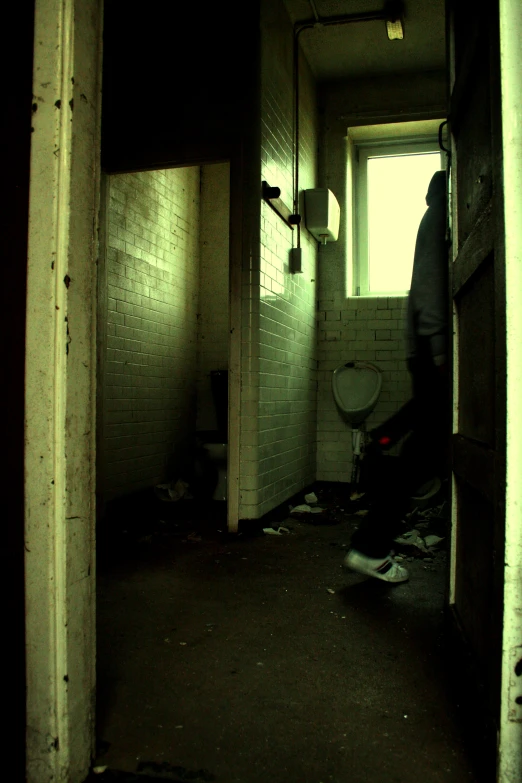 a person walks out the doorway of an old rundown building