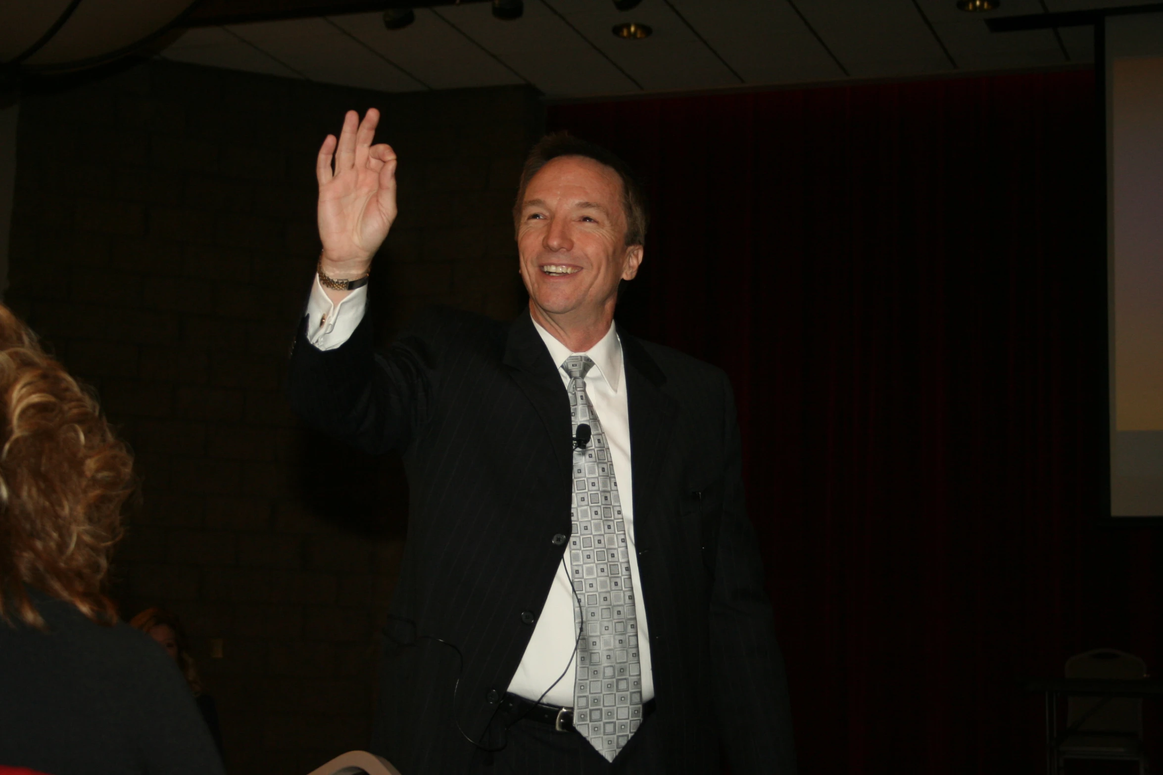 a man in suit and tie waving with a woman
