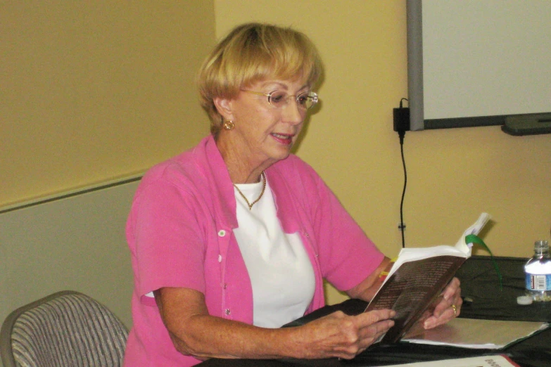 an older woman sits in front of a laptop computer