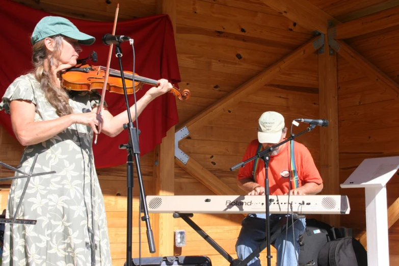 two men with hats playing violin and keyboard