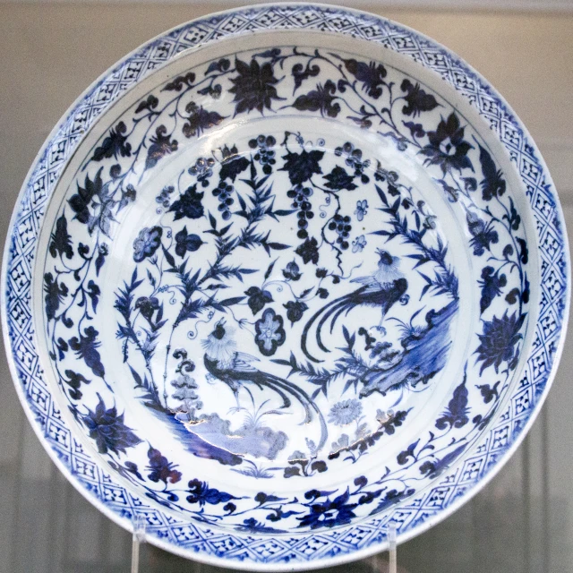 a large blue and white dish with flowers and birds