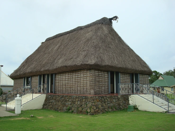 an unusual thatched roof structure on a house with stairs