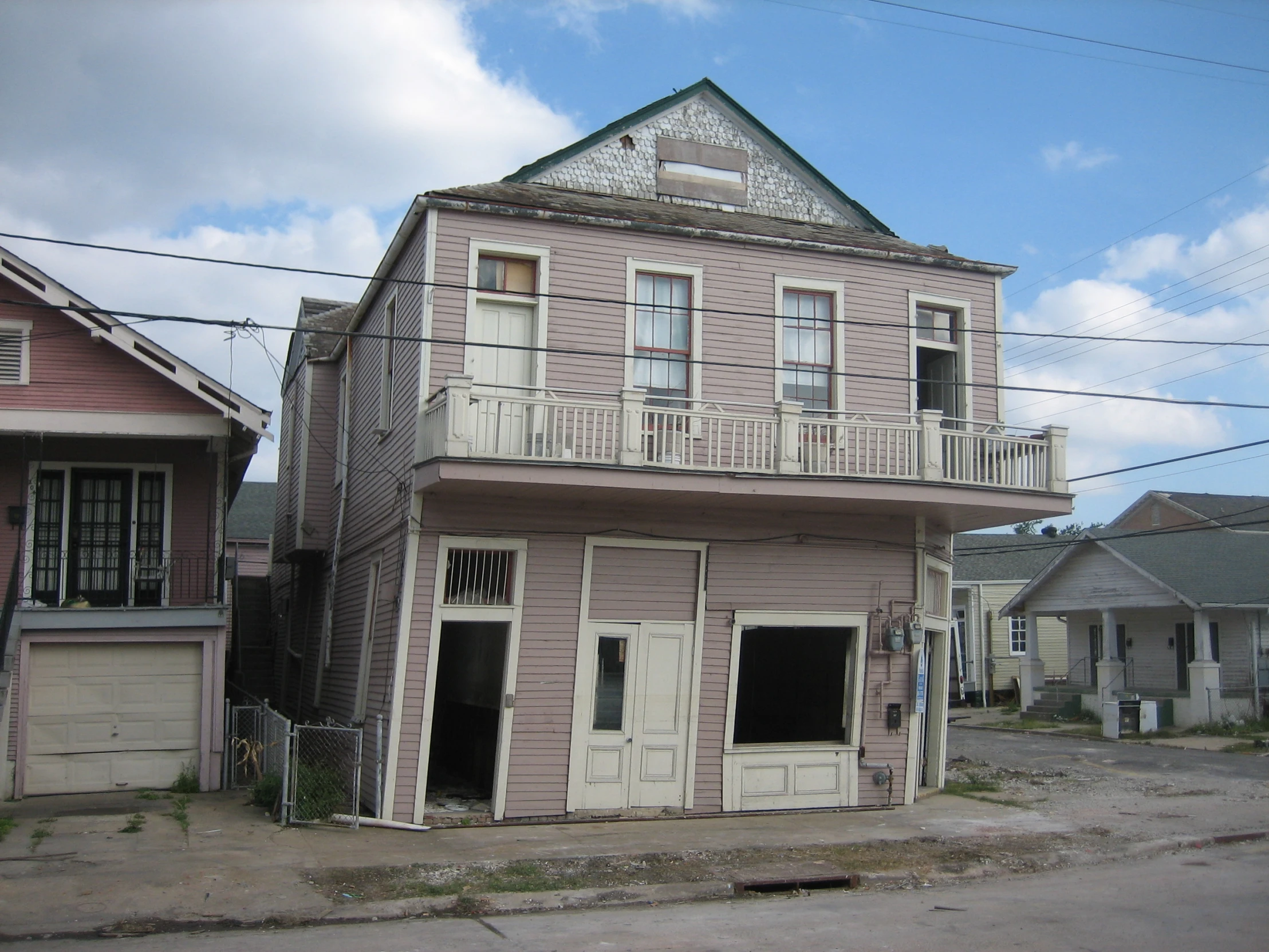 an old wooden building on the corner of a street