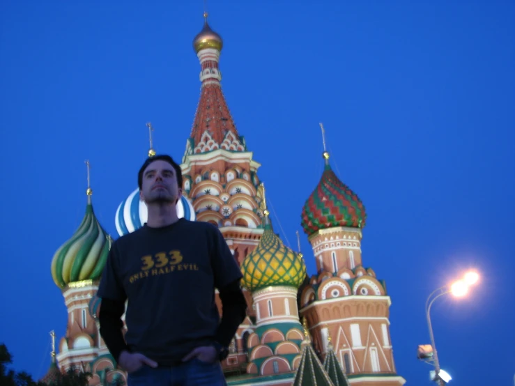 a man standing outside of an ornate building at night