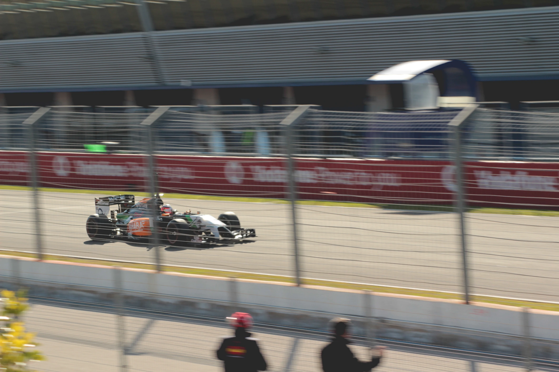 three people are watching a race while sitting in a racing car