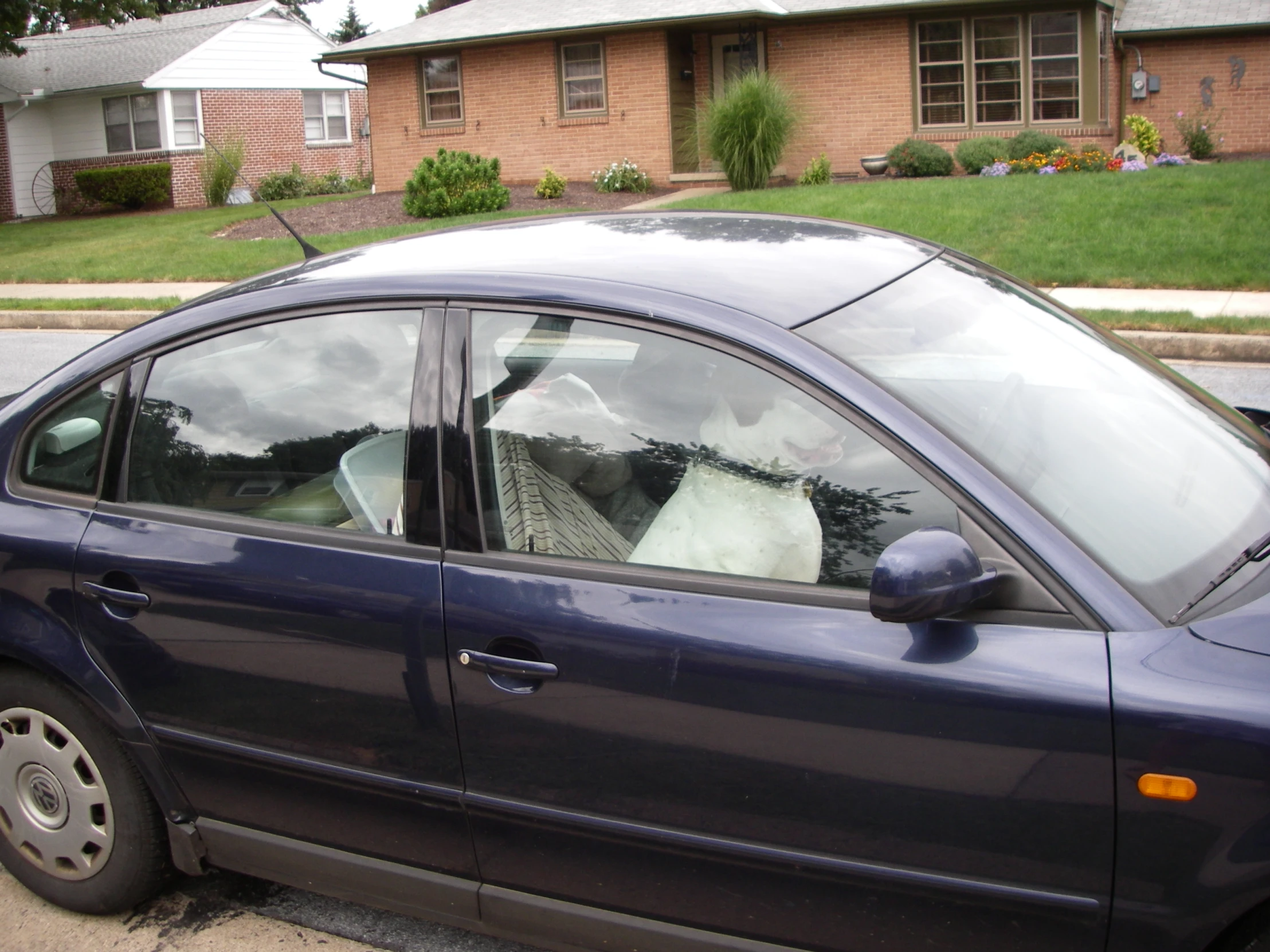 a car with windows partially open parked in front of a house