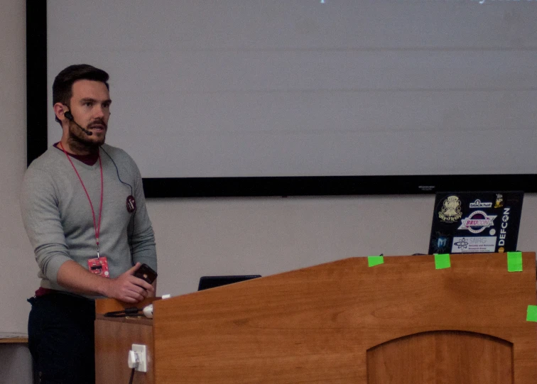 a man standing in front of a stage giving a talk