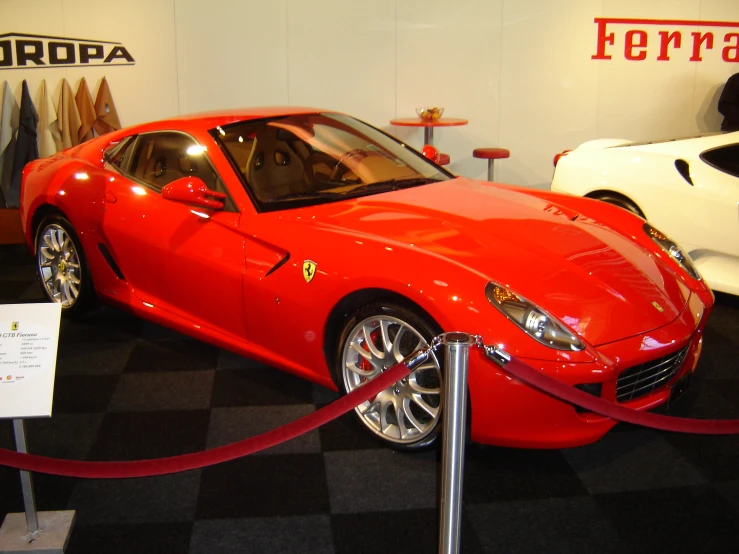 a red sports car is being displayed on the floor