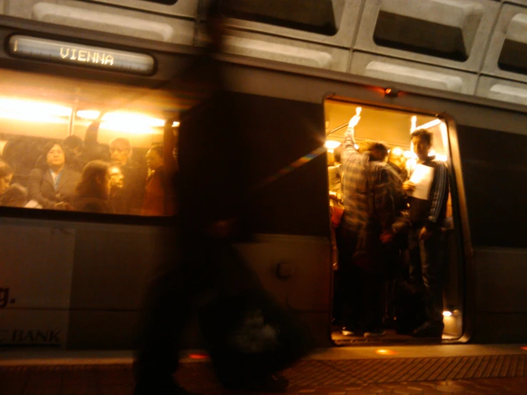 people standing on the side of a train waiting for a light show