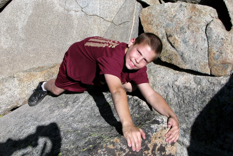 a man is climbing up on rocks near the ocean