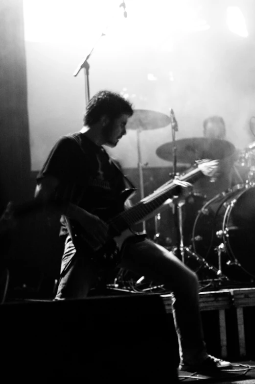 a man sitting in front of a drum set while playing