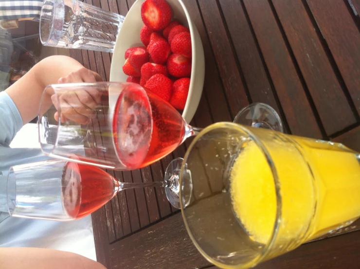 two glasses of wine and strawberries on a table