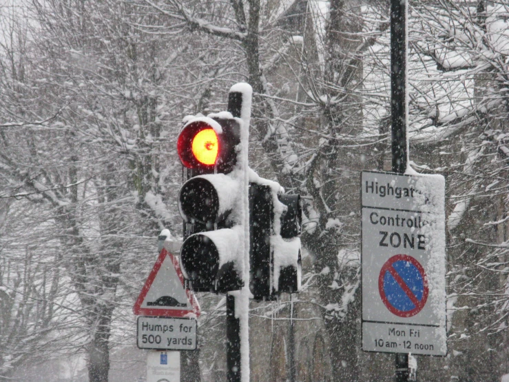 traffic lights on street with snow falling down