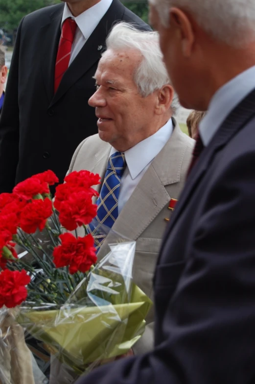 two men standing beside each other talking and smiling