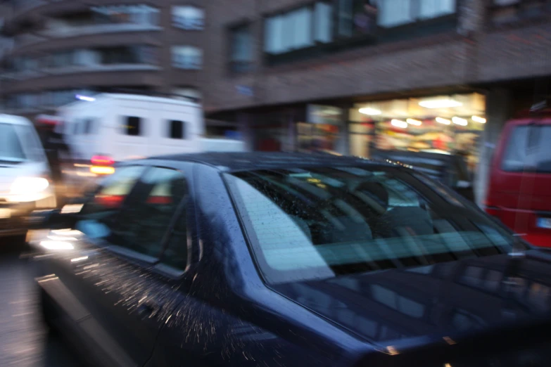 cars driving down a street near tall buildings