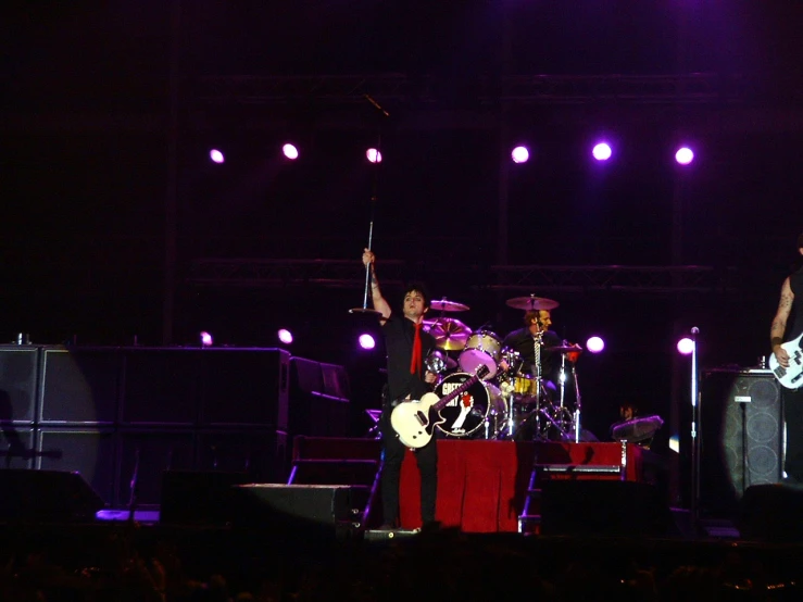 two men standing on a stage playing instruments