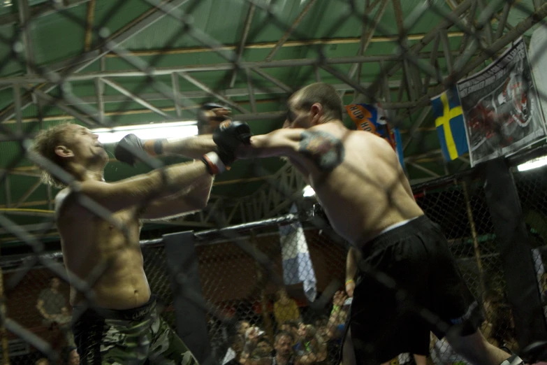 two men in a caged - in arena boxing