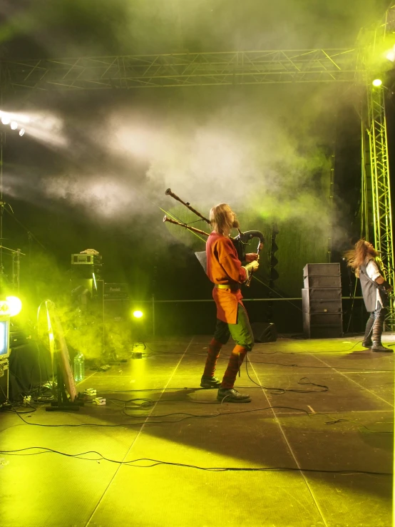 a man holding a bunch of big wooden bats on stage