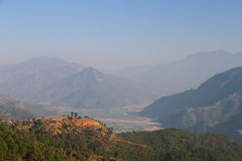 there are mountains in the distance as seen from a hill