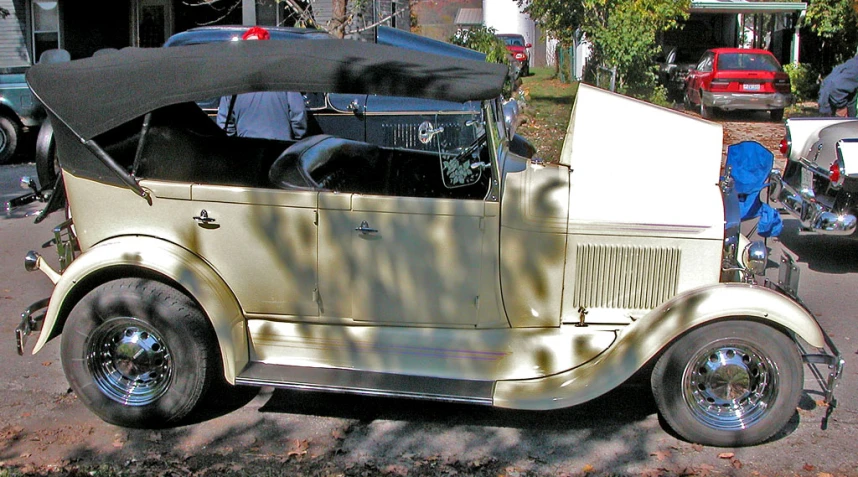 an old car with open hood sitting on the side of a street