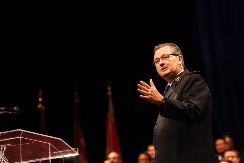 a man standing at a podium in front of a crowd