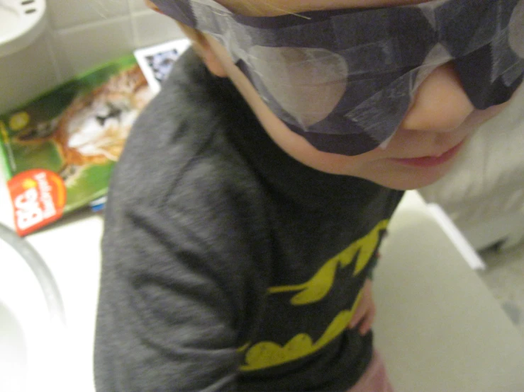  wearing a batman t - shirt and goggles