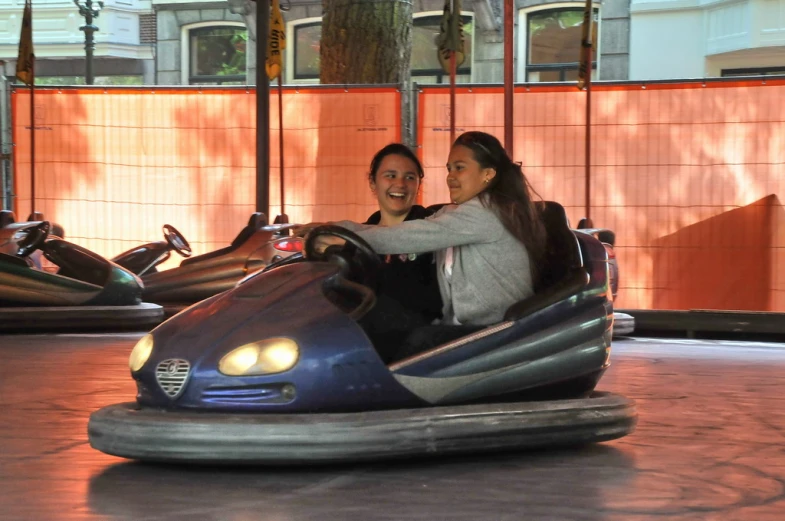 two people riding on an electric bumper car