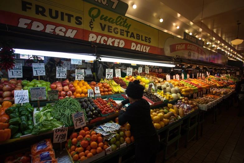 people looking through the fruit and vegetable section at a market