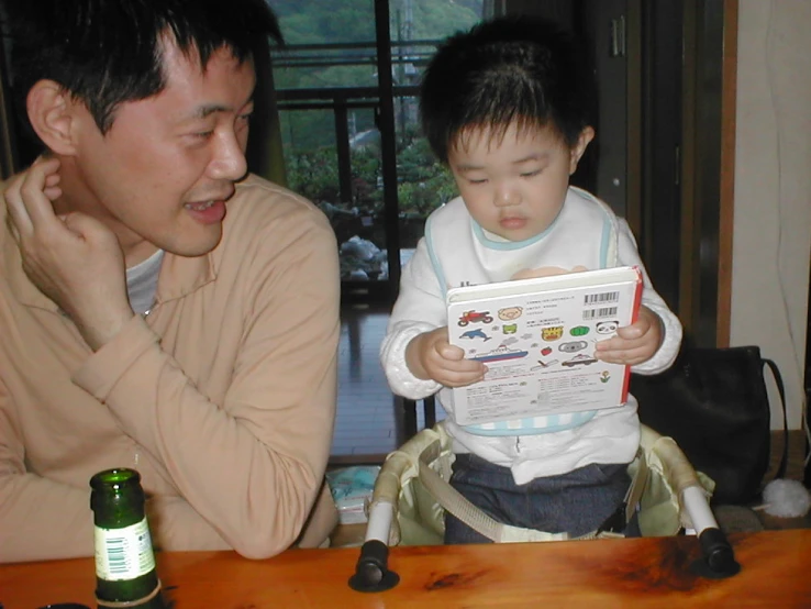 a man reading a magazine to a child