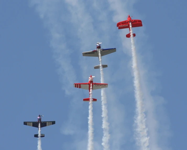 four stunt planes flying through the sky in formation