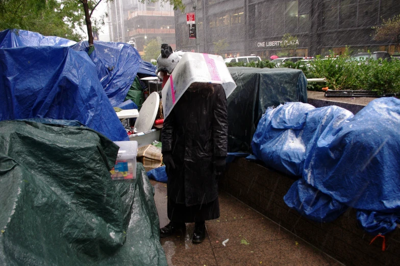 an umbrella covering the back of a woman standing on a street corner