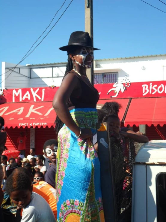 the lady in the colorful dress is standing at a bus stop