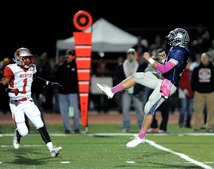 a football player jumping into the air to catch a ball