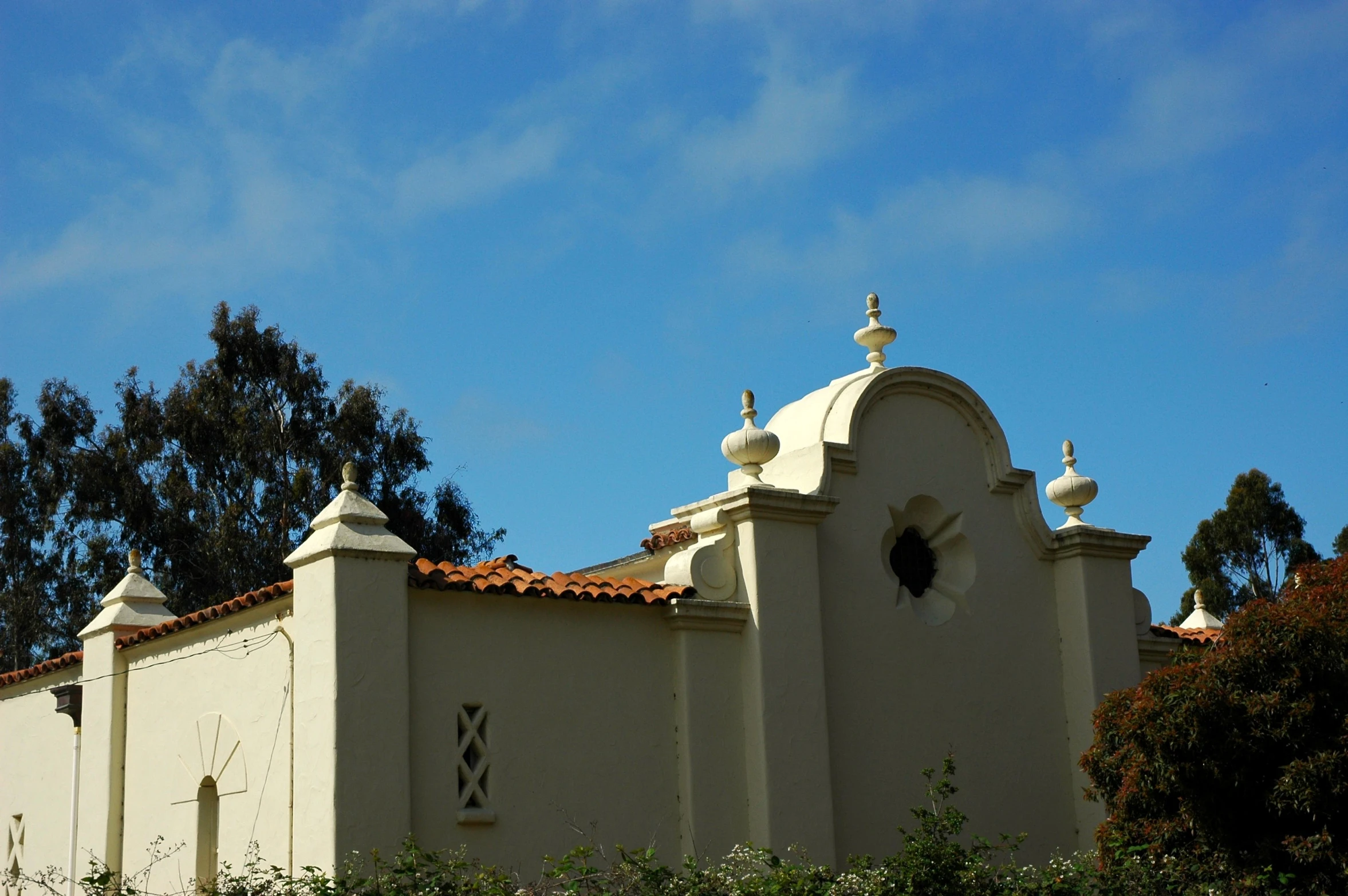 an old white building with many domes and vines