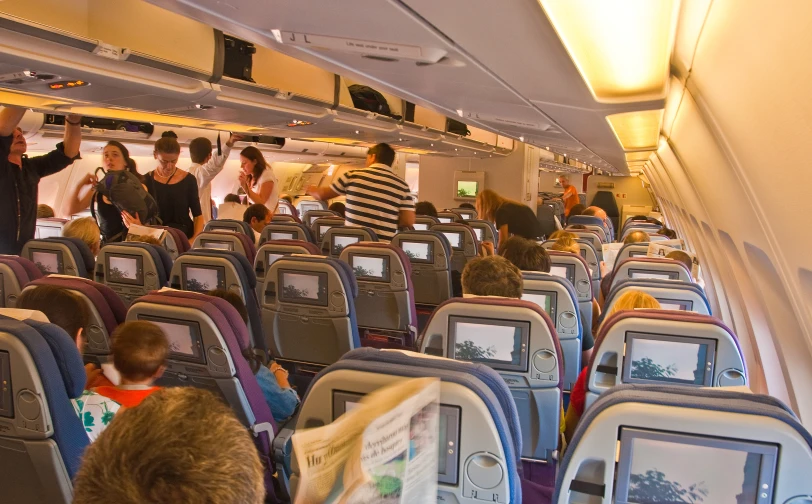 a big empty airplane with people standing in the aisle