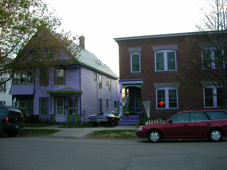 an orange car parked in front of purple houses