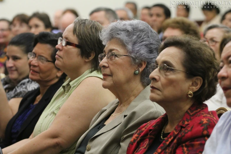 several elderly people sitting down in an auditorium