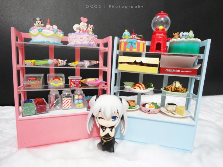 a toy stands in front of a pink, blue and green display case