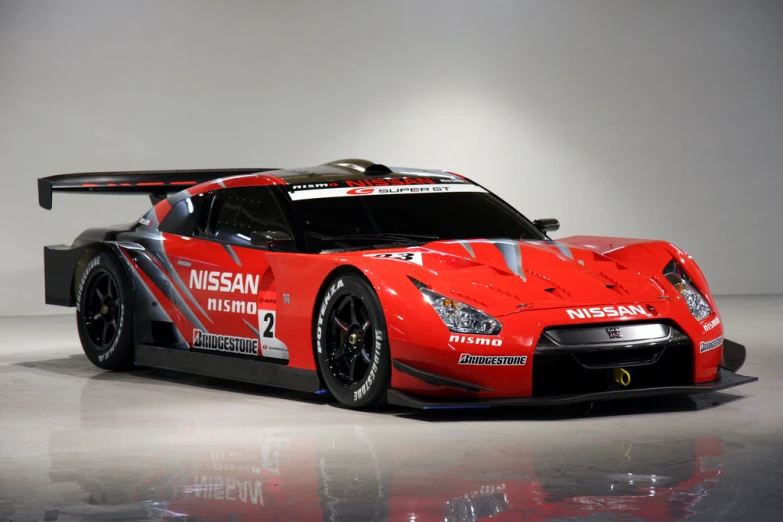 a red sports car parked on top of a hard surface