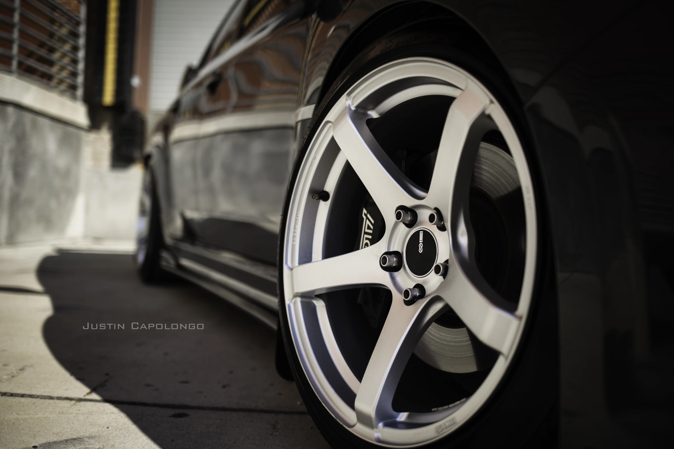 the front wheels of a car parked on a sidewalk