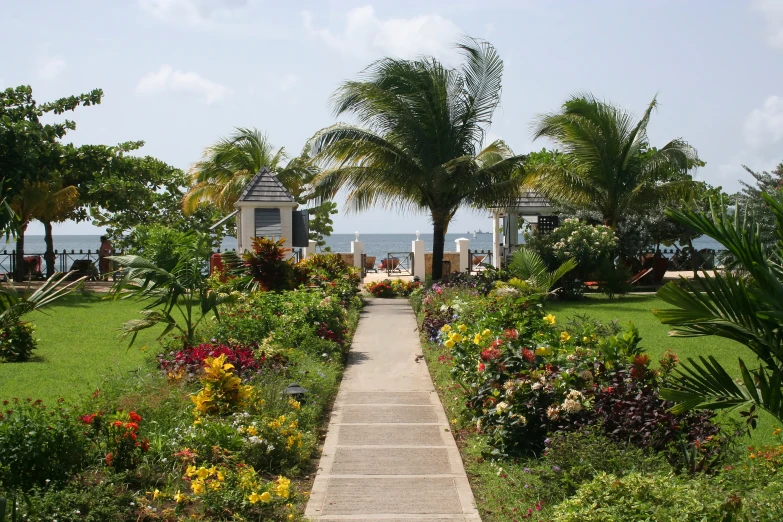 a path leading to an overhanged building that overlooks the water