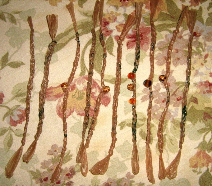 a collection of various stringed beads are arranged on fabric